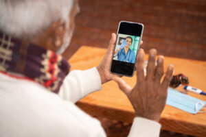 Photo showing older person on a telehealth visit on their phone.