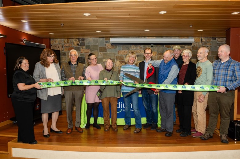 Group of people cutting a ribbon.